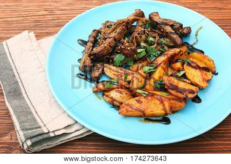 Homemade Slow Cooked Beef with Potatoes on wooden background