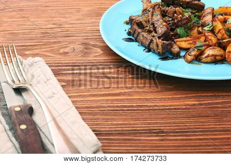 Homemade Slow Cooked Beef with Potatoes on wooden background