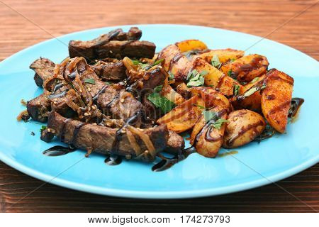 Homemade Slow Cooked Beef with Potatoes on wooden background