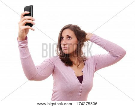 young woman making duckface while taking a selfportrait with her smartphone