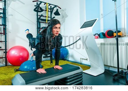 The female athlete doing they exercise in the EMS fitness studio