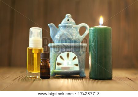 The small blue oil warmer with the candle inside placed on a wooden surface.