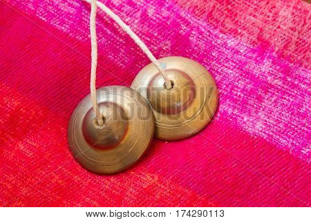 tibetan bell tingsha on pink wool .