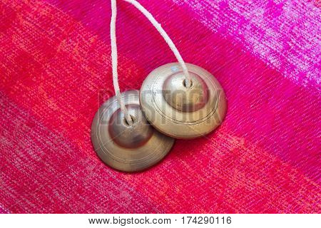 tibetan bell tingsha on pink wool .