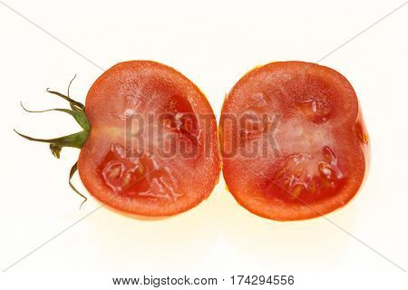 Ripe tomatoes cut into two halves on white background.
