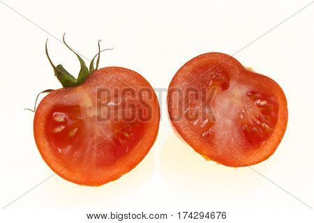 Ripe tomatoes cut into two halves on white background.