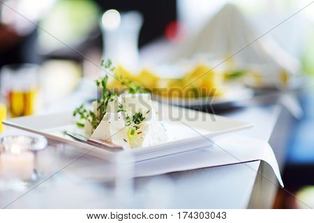 Different Kinds Of Wine Snacks And Variuos Cheeses On White Table