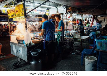 CHIANG MAI THAILAND - AUGUST 27: Father and sun cooking food at the Saturday Night Market on August 27 2016 in Chiang Mai Thailand.