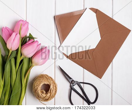 Pink Tulips And Envelope With Blank Papr On The White Wooden Tab