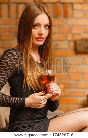 Woman Tasting Wine In Rural Cottage Interior
