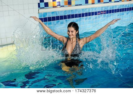 Young beautiful woman relaxing in swimming pool