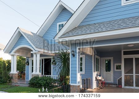 Bright Blue House In Sunlght With Colorful Poppies And Some Graceful Trees