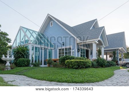 Bright Blue House In Sunlght With Colorful Poppies And Some Graceful Trees.