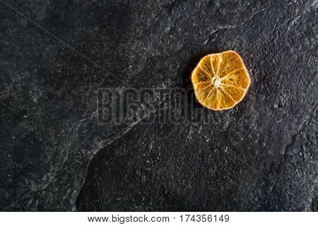 Dry Slices Of Citrus Fruits On A Black Slate Background.