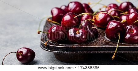Black Cherries In Vintage Dish. Stone Background.