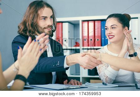 Male and female handshake in office. Serious business and partnership concept. Partners made deal sealed with handclasp.