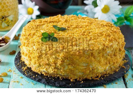 Homemade Honey Cake With Sour Cream On A Wooden Table With Raisins And Nuts.