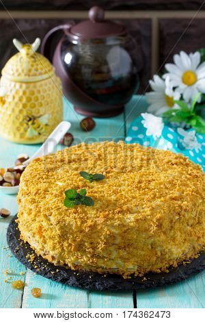 Sweet Home Layered Honey Cake On A Wooden Table With Raisins And Nuts.