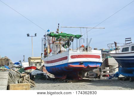 CABO DE GATA SPAIN - FEBRUARY 9 2016: Fishing boats at the shore of national park Cabo de Gata near Almeria (Andalusia Spain) and sea waves on the background.