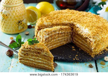 Sweet Home Layered Honey Cake On A Wooden Table With Raisins And Nuts.