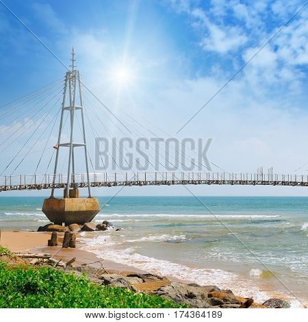 The bridge to the island the ocean and the sun in the blue sky (Matara Sri Lanka)