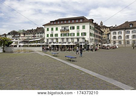 RAPPERSWIL SWITZERLAND - MAY 10 2016: Buildings on the Fish Market square (Fischmarktplatz). There are many outdoors restaurant in which a lot of people can be seen in a distance