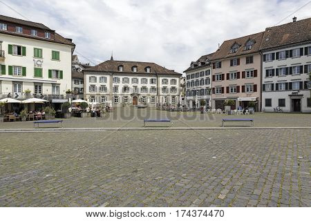 RAPPERSWIL SWITZERLAND - MAY 10 2016: Historic buildings around the square called Fischmarktplatz. There are people who are in the outdoor seating areas of various cafes and restaurants