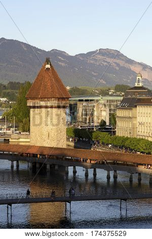 LUCERNE SWITZERLAND - MAY 06 2016: Octagonal tower is named Wasserturm was built in the river Reuss and is located behind Chapel Bridge both are the most famous city landmark