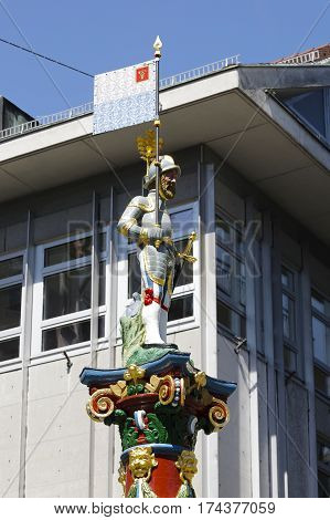 LUCERNE SWITZERLAND - MAY 06 2016: The figure of a man in the helmet with a flag and a sword who stands on top of the colorful and ornate pillar of the Fritschi Fountain.