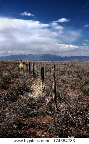 A long fence line in the San Luis Valley of southern Colorado near Alamosa and the Great Sand Dunes National Park.