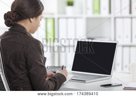 Rear View Of Woman With A Laptop In Office