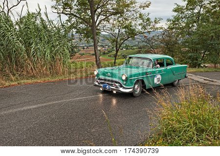MELDOLA FC ITALY - SEPTEMBER 18: driver and co-driver on a vintage American car Oldsmobile Super Rocket 88 (1954) in classic car rally 