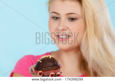 Woman Holding Chocolate Cupcake About To Bite