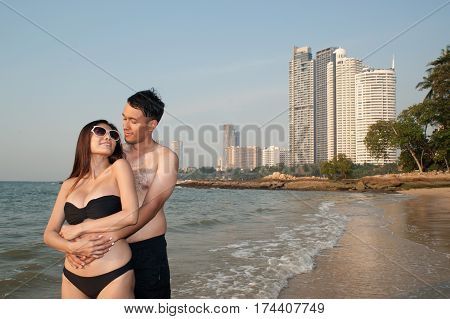 Lovely young adult couple standing on the beach.