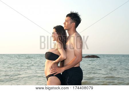 Lovely young adult couple standing on the beach.