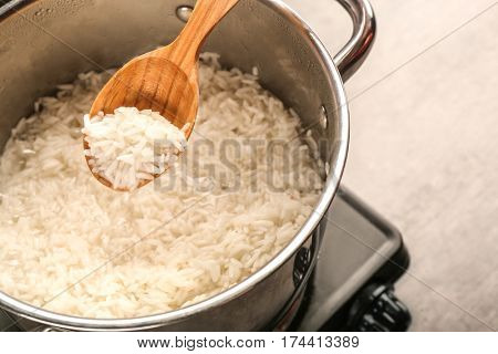 Cooking rice in metal pan on hotplate in kitchen