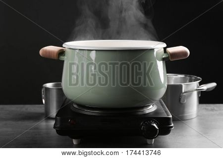 Cooking rice in metal pan on hotplate in kitchen