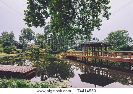 Japanese garden in Wroclaw, Lower Silesia, Poland. Natural park view with little japan pagoda, wooden bridge and small pond.
