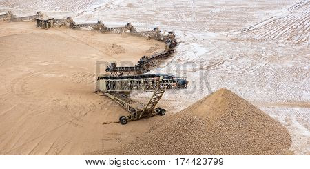 Conveyor belt of heavy machinery loads stones and gravel
