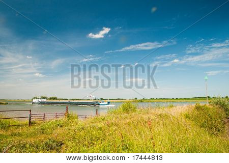 Landscape with river the Lek and cargo boat in Holland
