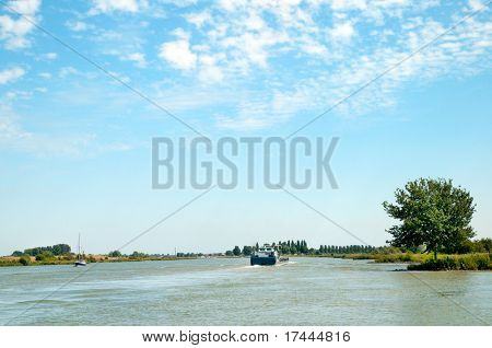 Landscape with river the Lek and cargo boat in Holland