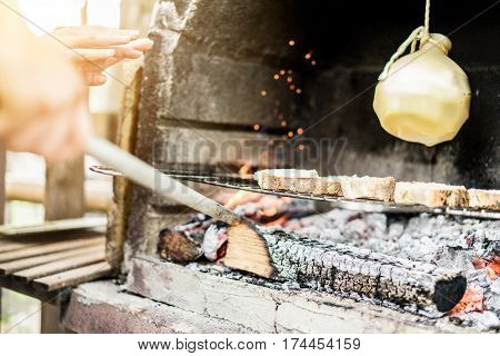 Young man cooking caciocavallo cheese with bread in barbecue dinner - Chef grilling special italian dish for bbq - Concept of eating outdoor during summer time - Focus on woman hand - Warm filter