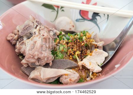 Thai Fusion Food dry noodle with pork in ceramic bowl with Thai style spice