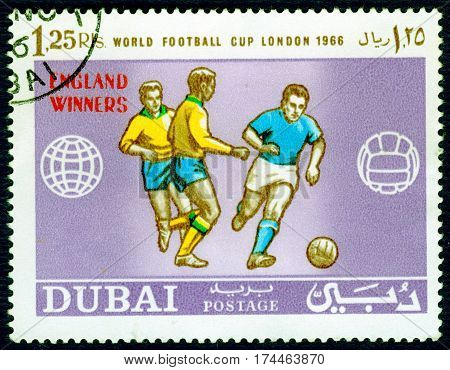 DUBAI - CIRCA 1966: Postage stamp printed in Dubai  with a picture of a football players, with the inscription 