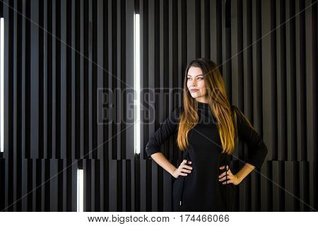 Young business woman in front on wall in office