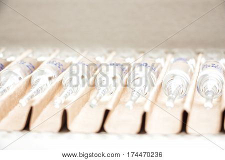 Row of transparent medical ampules in package. Close up
