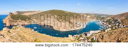 Beautiful view of the Black Sea and the city Balaklava. Balaklava Bay. Genoese fortress in mountains. Clear summer day and a top view of the port