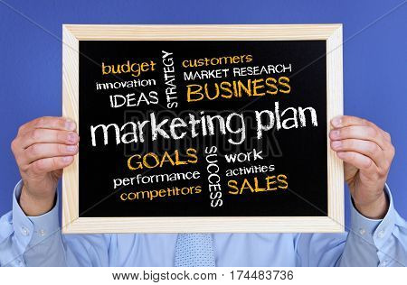 Marketing Plan - Businessman holding chalkboard with text