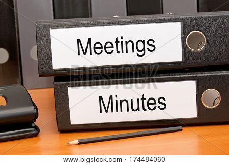 Meetings and Minutes - two binders on desk in the office