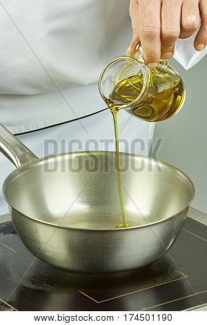 Chef pours oil into the pan for cooking
